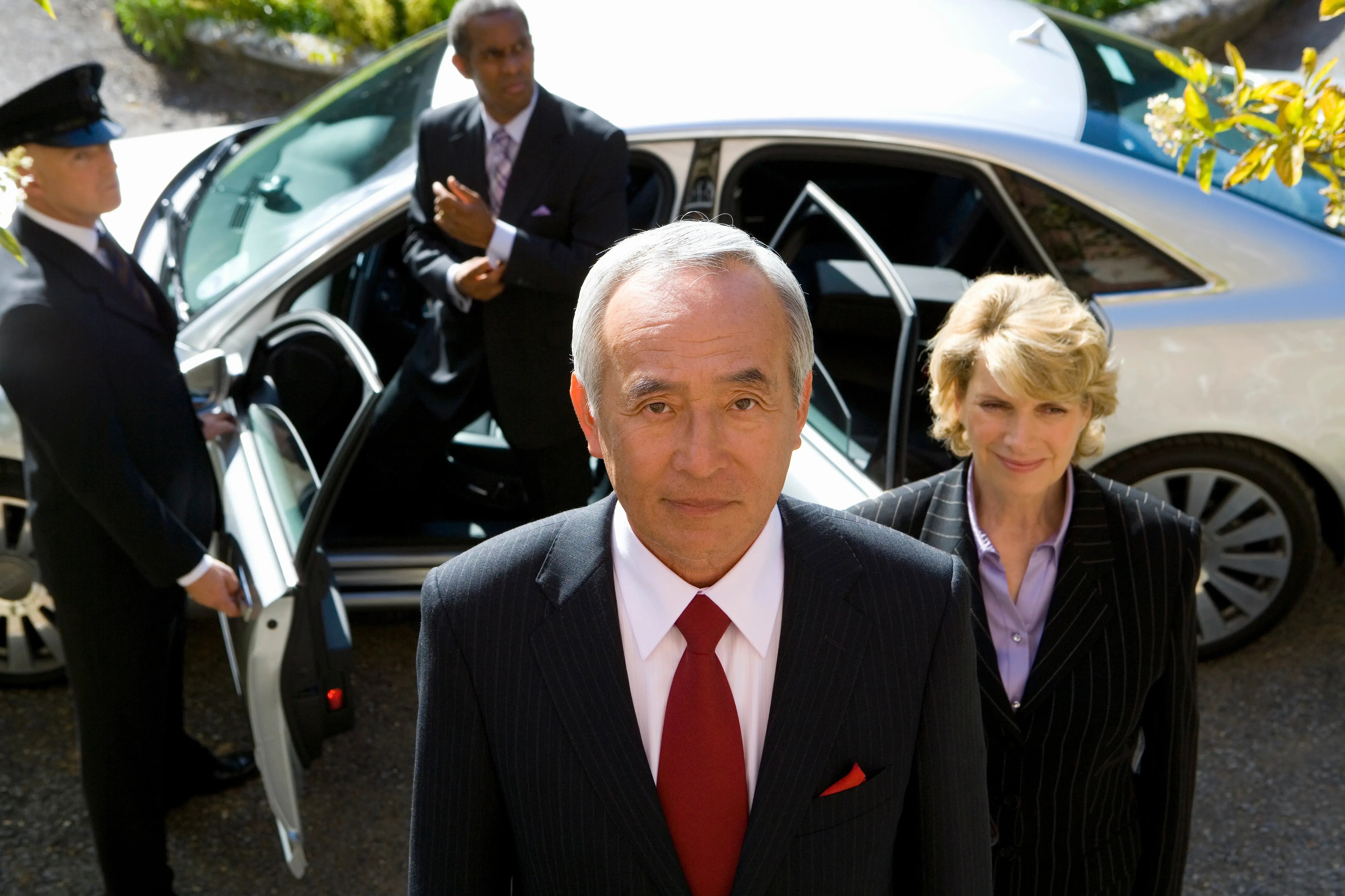 businessman-and-colleagues-getting-out-of-chauffeu-2026-01-11-08-03-03-utc