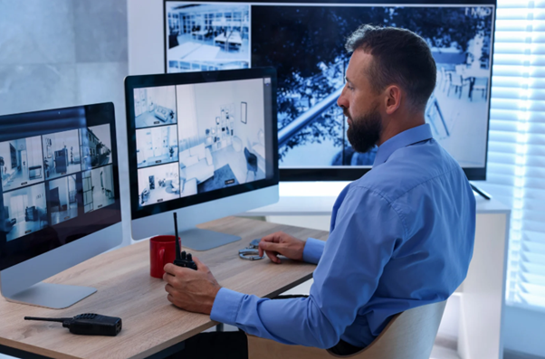 Residential security professional monitoring multiple CCTV feeds from a control room, highlighting high-end home security measures designed to protect privacy and safety for ultra-high-net-worth families.